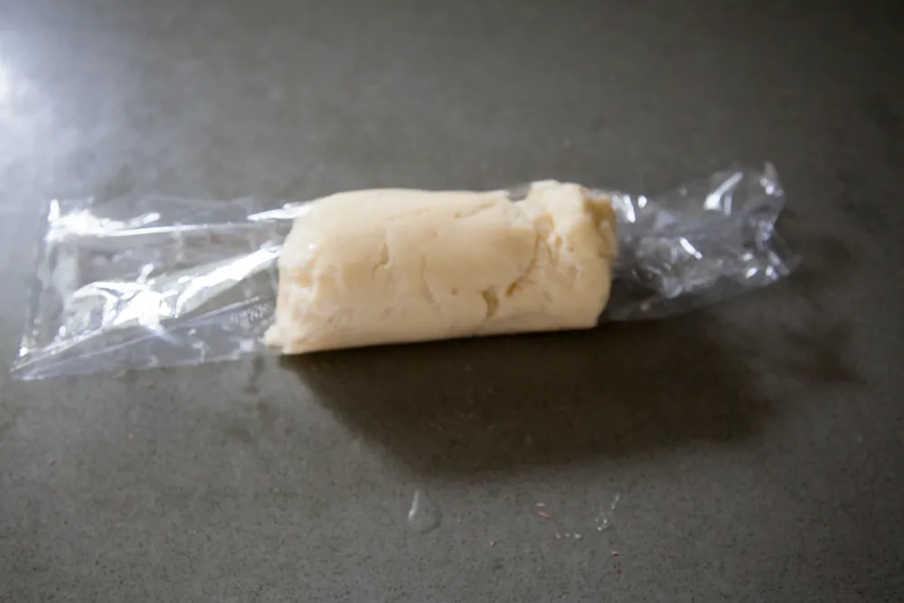 Gently wrap the plastic wrap around the butter, evening it out with your fingers.